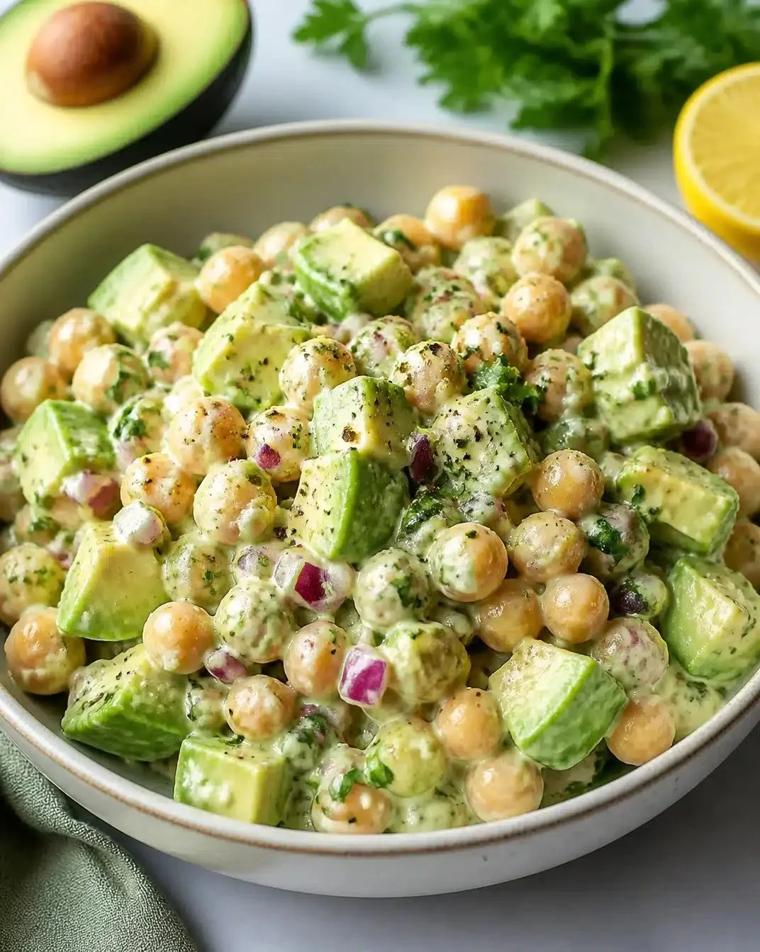 Creamy Chickpea and Avocado Salad 1 Creamy chickpea and avocado salad served in a bowl garnished with herbs.