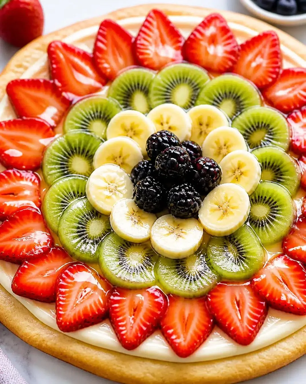 Colorful fruit pizza topped with glaze for a refreshing dessert