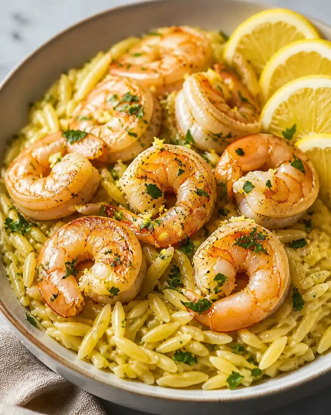 Plate of lemon garlic shrimp with orzo pasta, garnished with parsley