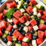 Fresh watermelon salad with feta cheese and mint leaves served in a bowl